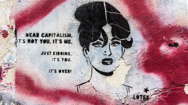 Stenciled mural reading "Dear Capitalism, it's not you, it's me. Just kidding. It's you. It's over!" with a stylized woman wearing a bouffant and disgusted look in black outlined in red spraypaint.